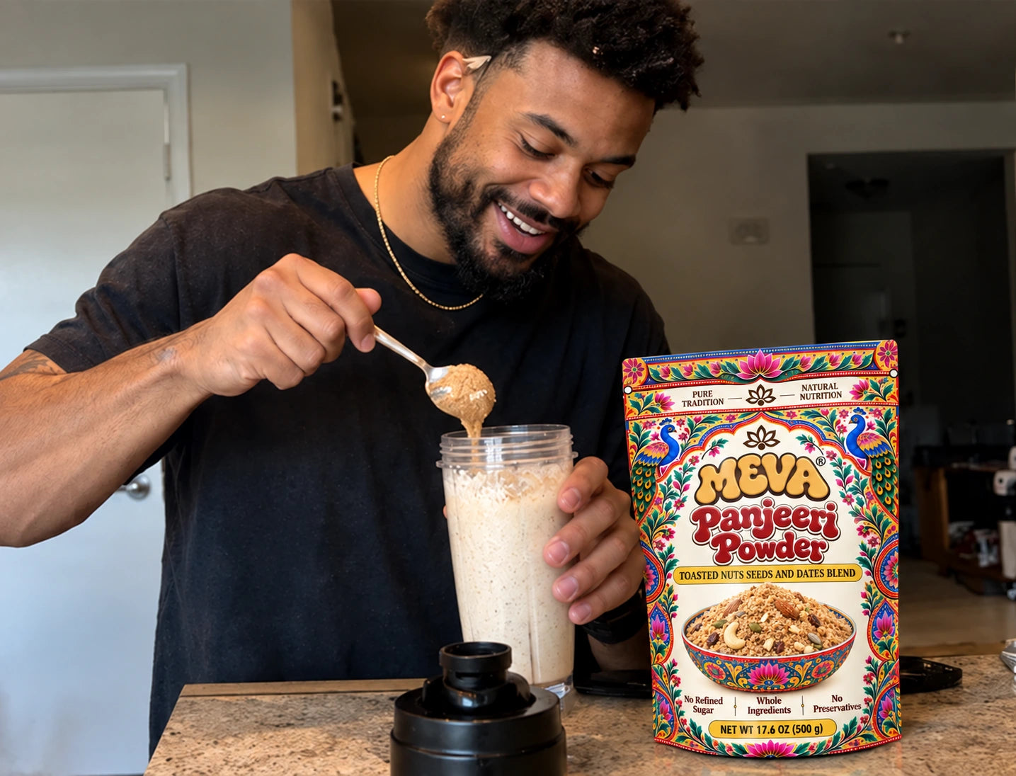 A man spooning MEVA Panjeeri Powder into a smoothie in his kitchen